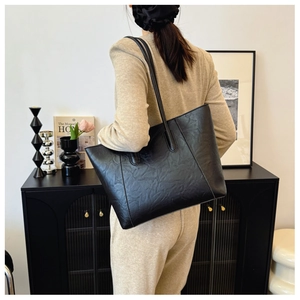 Close-up of black retro tote bag with soft pleated texture and comfortable shoulder strap