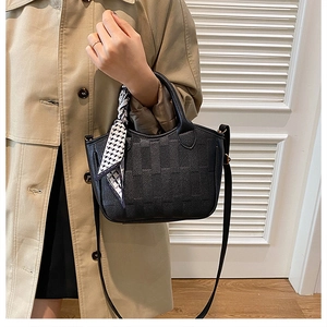 Detail of black textured bucket bag with checkered scarf wrap and adjustable strap