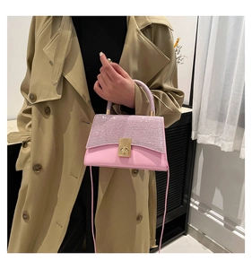Detail of pink sequin square handbag with golden metal lock and smooth PU material
