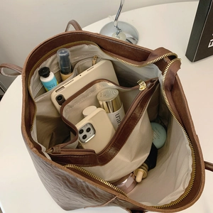 Brown leather tote bag showing large capacity for tablet and cosmetics with organizer