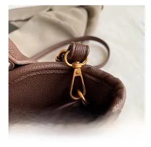 Detail view of coffee brown lychee grain leather handbag with vintage bronze metal swivel hook