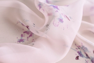 Gros plan sur l'écharpe de plage rose avec motif floral violet et texture légère