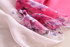 Détail du tissu d'un foulard en soie rose dégradé avec motif floral et texture légère