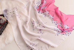 Gros plan d'un foulard en soie léger avec imprimé cerisier rose et texture douce