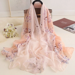 Élégant foulard en soie pêche avec imprimé cerisier drapé sur un sac à main en cuir
