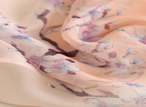 Gros plan sur le tissu soyeux de l'écharpe avec imprimé fleurs et texture drapée douce