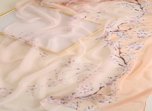 Détail d'une écharpe en soie avec imprimé cerisier et dégradé rose élégant et fluide