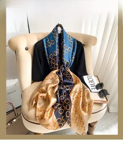 Detailed texture of navy and gold silk scarf with vintage chain patterns on an armchair