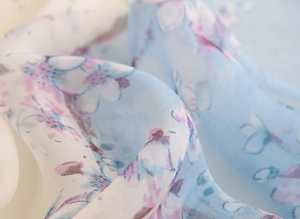 Gros plan du tissu de l'écharpe florale légère en bleu clair et blanc avec des plis