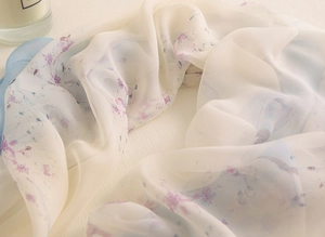 Gros plan d'une écharpe en soie légère montrant des plis et des motifs floraux élégants