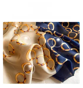 Detail of imitation silk scarf showing smooth texture with champagne and navy geometric patterns