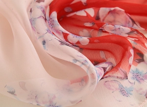 Gros plan d'un châle en mousseline fleurie semi-transparente aux motifs de cerisiers roses