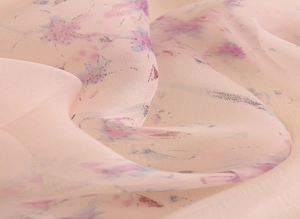 Vue macro d'une écharpe en mousseline rose avec d'élégants imprimés floraux mauves