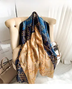 Detail of silk-feel scarf with vintage gold chain print and dark blue color block