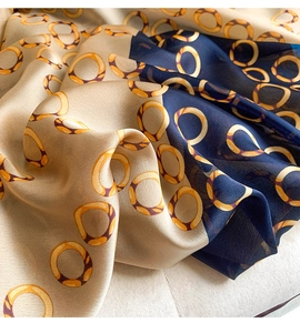 Detailed close-up of silk scarf showing champagne and navy block colors with ring patterns