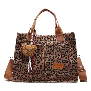 Leopard print canvas tote bag with front pockets and plush bear keychain accessory