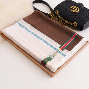 Detail of silk-like scarf featuring classic metal horsebit and luxury belt patterns