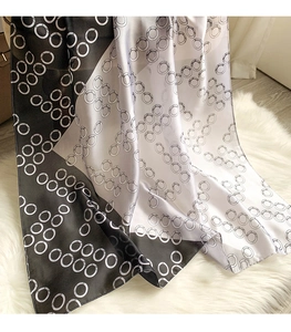 Detail of black and white silk scarf with geometric ring patterns on plush texture