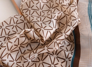 Detailed view of elegant silk scarf featuring geometric patterns and houndstooth texture