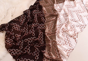 Close-up of silk-like satin scarf with brown gradient colors and chain patterns