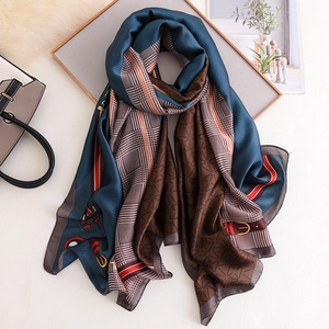 Detail of elegant silk scarf with equestrian chain print and classic houndstooth pattern