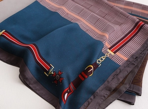 Macro detail of high-quality silk scarf featuring equestrian chain and buckle prints