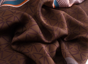 Detailed close-up showing satin silk texture with star patterns and houndstooth borders