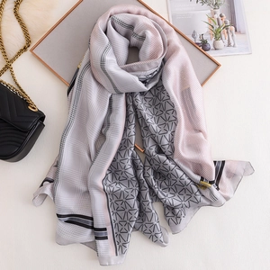 Elegant geometric star print silk scarf in pink and grey for sun protection and styling