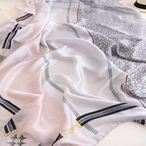 Detail of silk-like scarf with gold chain patterns and elegant pink grey patchwork