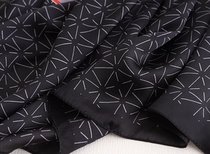 Detail of silk scarf with traditional white geometric Asanoha pattern on black fabric