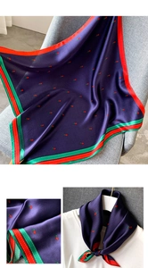 Détail de l'écharpe en soie bleu marine avec motif tulipe et bordure rayée contrastée