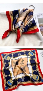 Vue détaillée du foulard en soie avec motifs équestres classiques et bordures rouges
