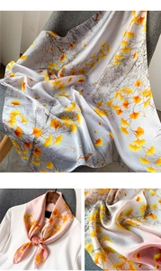 Détail du foulard en soie avec motifs de feuilles de ginkgo jaunes et texture fluide douce
