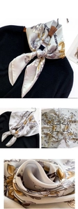 Détail d'un foulard en soie grise à fleurs avec reflet sur tissu noir