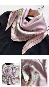 Détail d'un foulard en soie lavande avec des motifs floraux blancs et des lettres