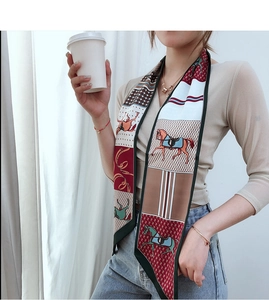 Elegant equestrian horse print narrow silk scarf styled as a neck tie on a beige sweater