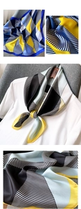 Détail d'un foulard satiné avec motifs géométriques et texture soyeuse sur t-shirt blanc