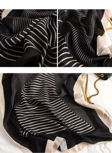 Détail d'une écharpe élégante à rayures noires et beiges avec une texture fine