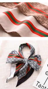 Close-up of silk scarf with interlocking patterns and striped ribbon tied in a bow