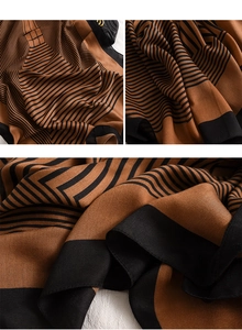 Détail d'une écharpe douce à rayures avec motifs géométriques caramel et noir