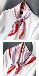 Détail d'un foulard en soie à pois rose et rouge noué sur un t-shirt blanc en gros plan