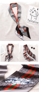 Detailed close-up of skinny silk scarf with classic stripes and playful cartoon print