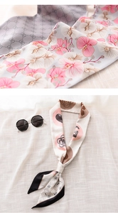 Detail of silk-like narrow scarf showing floral orchid prints and camellia patterns