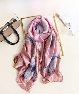 Detail of pink silk scarf with lotus print styled with luxury fashion accessories