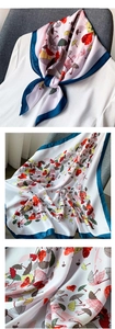 Détail d'un foulard en soie synthétique avec motifs cœurs et bordure bleu marine