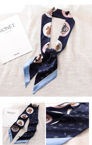 Detailed macro view of navy blue silk scarf with pink floral and clover prints