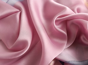 Close-up of soft pink imitation silk fabric showing smooth satin luster and texture