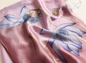 Detail of silk scarf showing lotus floral pattern with a smooth, glossy texture