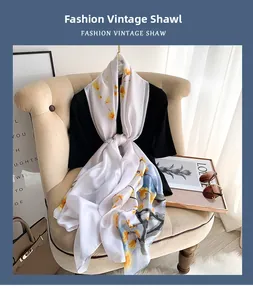 Close-up of elegant faux silk scarf with yellow floral ginkgo patterns on white fabric