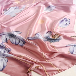 Detail of silk scarf with lotus print showing the smooth texture and soft pink fabric